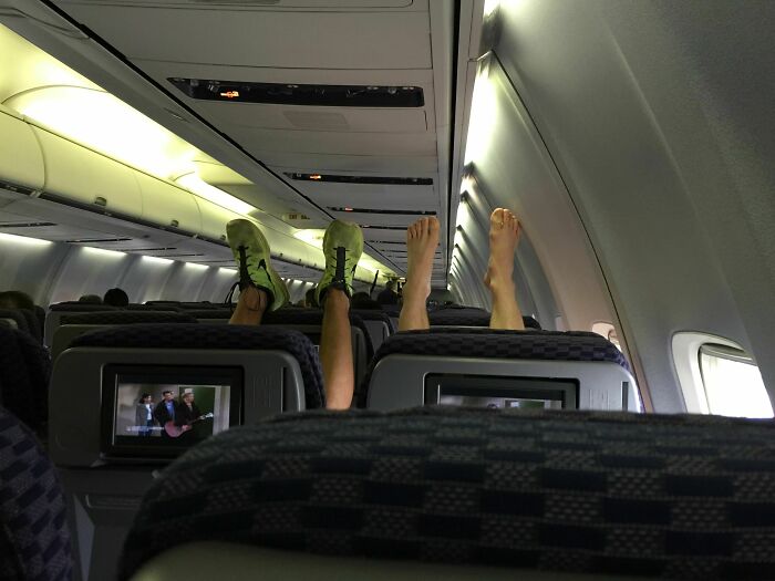 Feet up in airplane cabin, illustrating annoying plane passengers disrupting others.