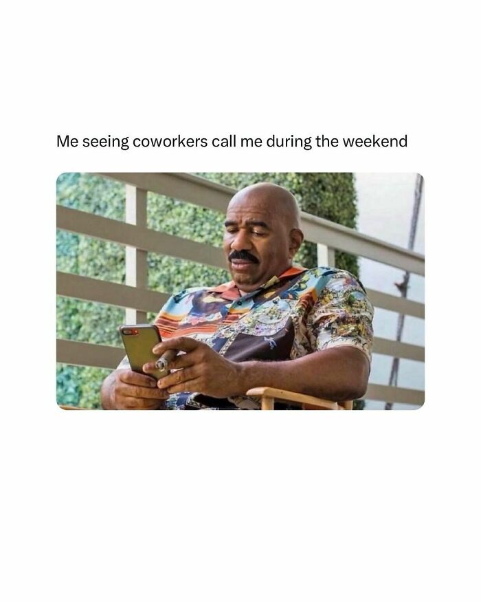 Man in colorful shirt, sitting outdoors, looking at phone with a perplexed expression.