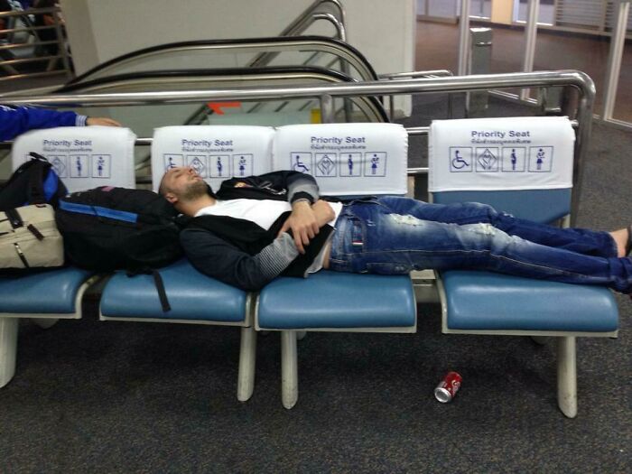 Passenger occupying priority seats in airport lounge with bags; an example of annoying plane passengers.