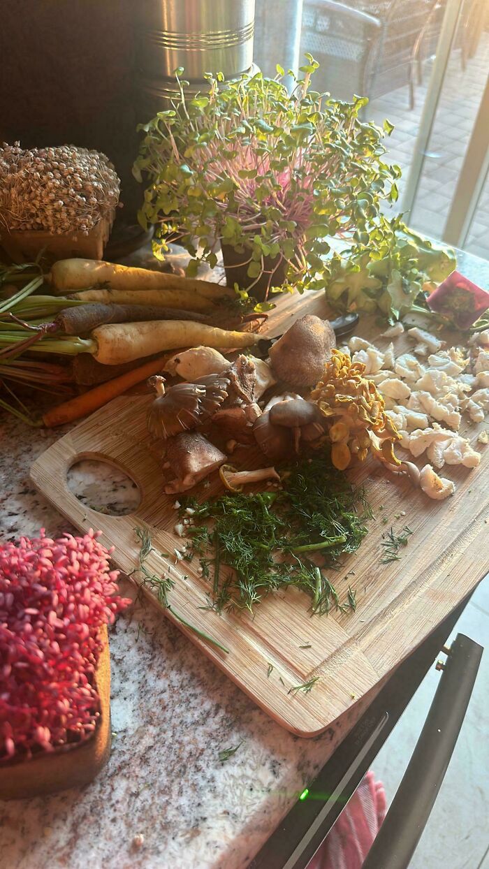 Fresh vegetables and mushrooms on a wooden board, resembling a Renaissance painting with soft natural light.