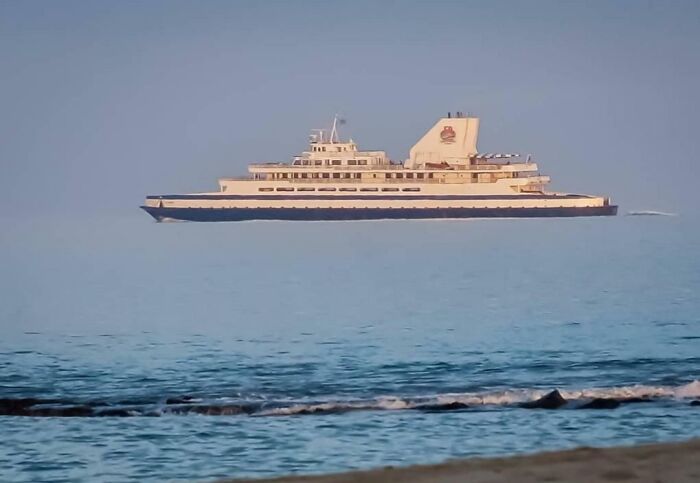 A large ship appears to hover above the ocean, showcasing an interesting not photoshopped visual effect.