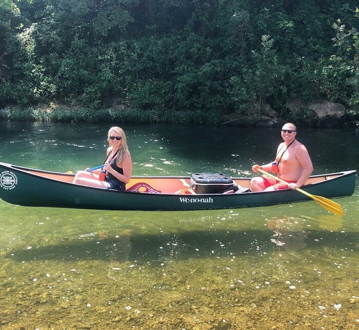 Two people in a canoe on clear water, creating the illusion of floating; an interesting not photoshopped photo.
