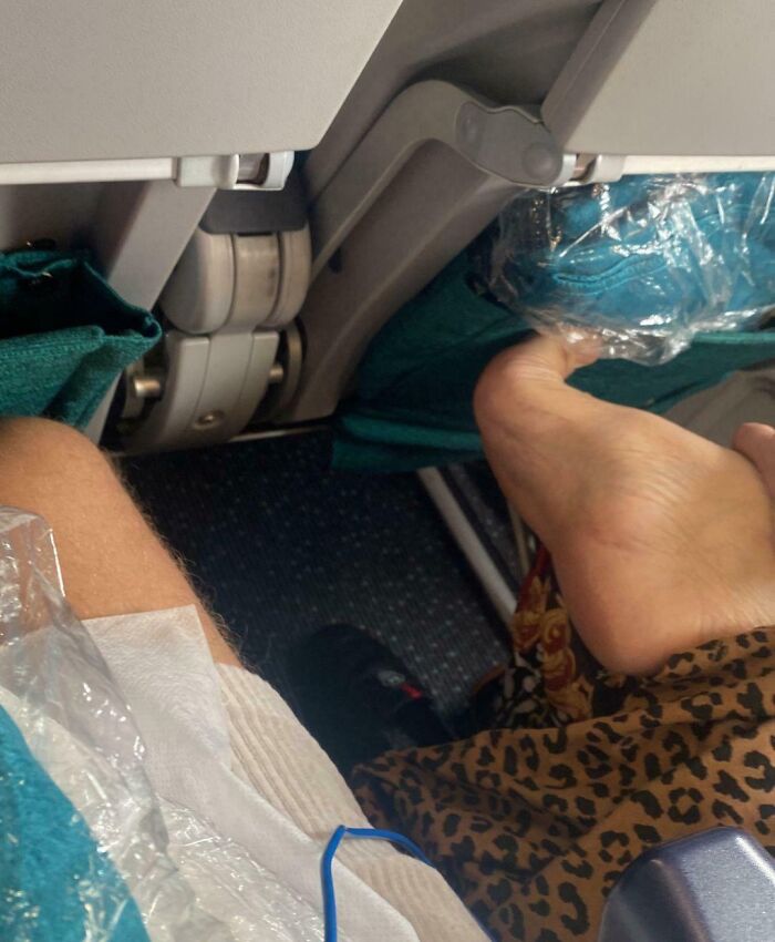 Annoying plane passengers with bare feet resting on seat, disrupting fellow traveler’s space.