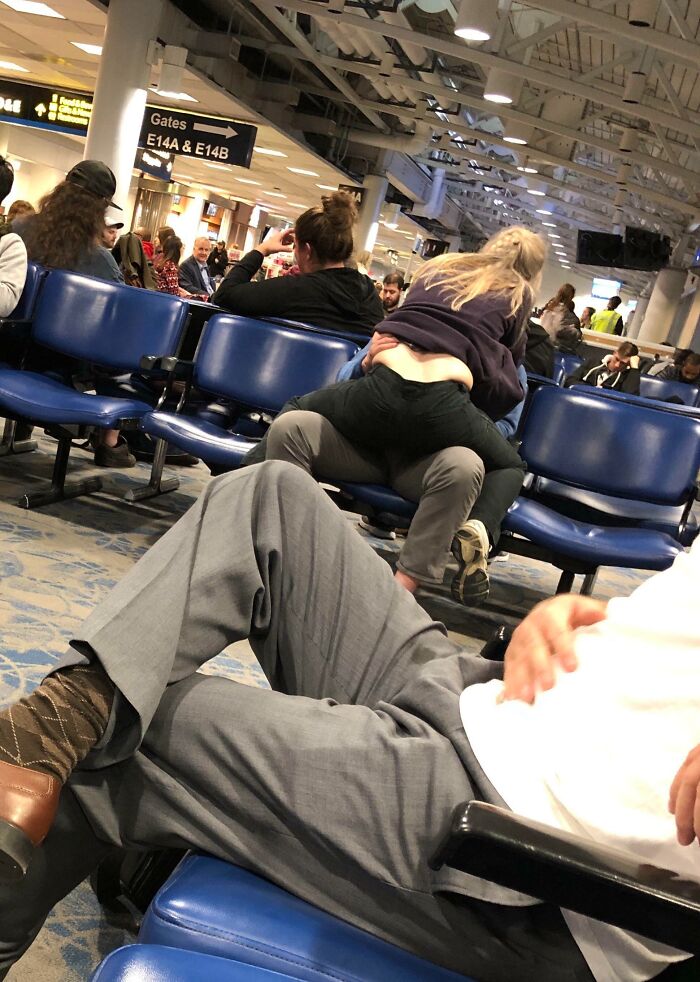 Crowded airport seating area with annoying plane passengers causing disruption.