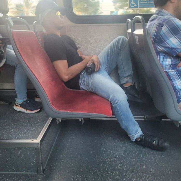 Person sprawled across bus seats, showcasing infuriating public transport passenger behavior.