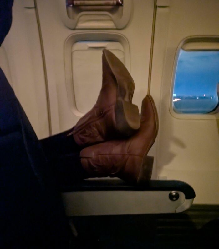 Feet propped on a plane seat, illustrating annoying plane passengers.