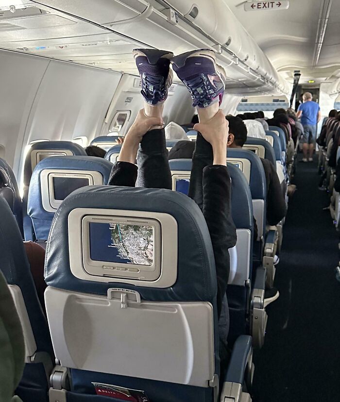 Passenger with feet up in airplane seat, demonstrating annoying-plane-passengers behavior.