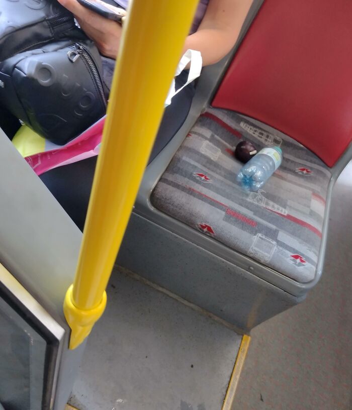 Public transport passenger spreading belongings on the seat.