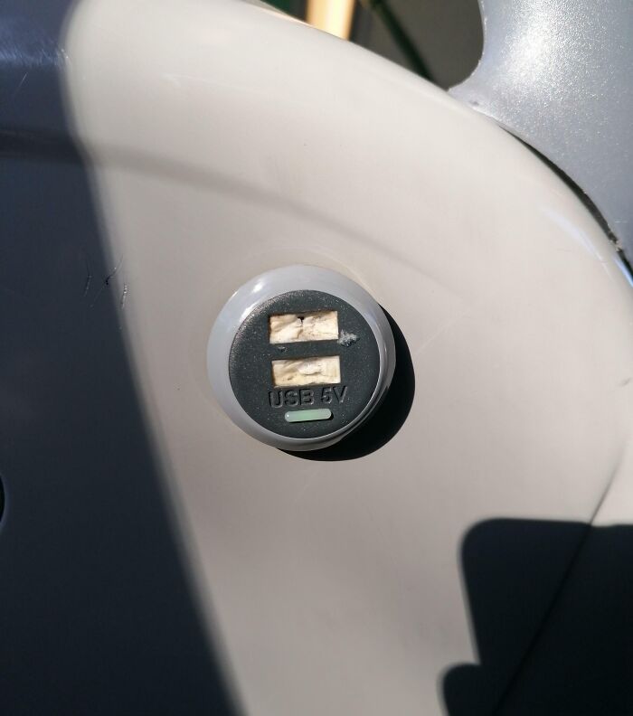 Broken USB port on public transport, causing frustration for passengers looking to charge devices.