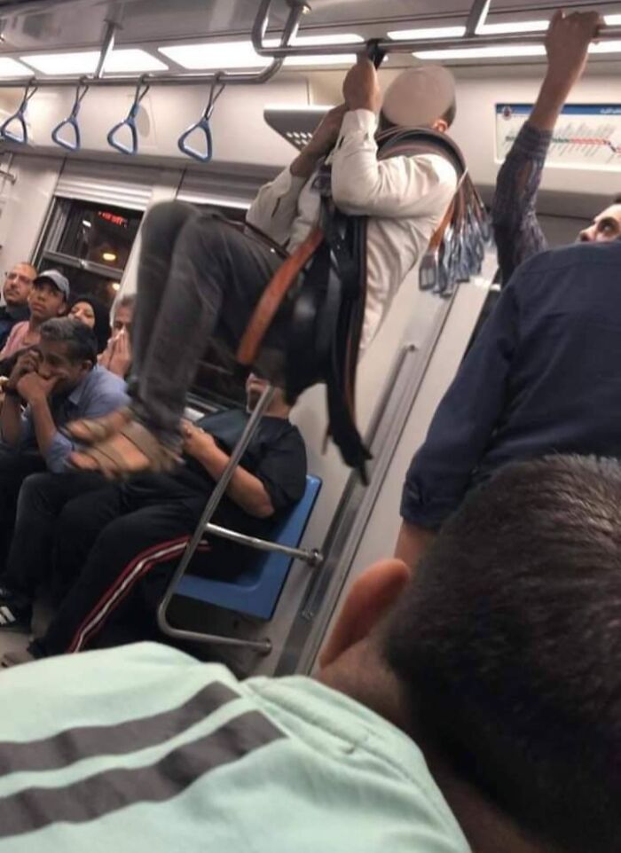 This Guy Hanging From One Of His Belts To Show People That His Belts Are Good Quality. Egyptian Metro Sellers Are A Different Species