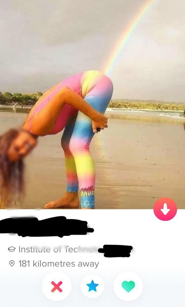 Person in rainbow outfit posing creatively on a beach for a unique Tinder profile photo.
