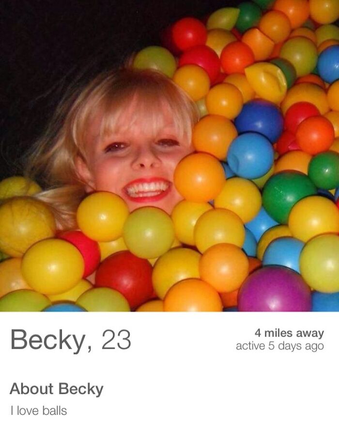 Person surrounded by colorful balls, smiling playfully for a quirky Tinder profile.