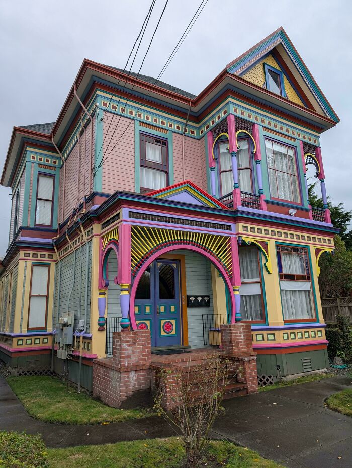 Colorful Victorian-style house showcasing impressive architectural feats with intricate woodwork and vibrant paint details.