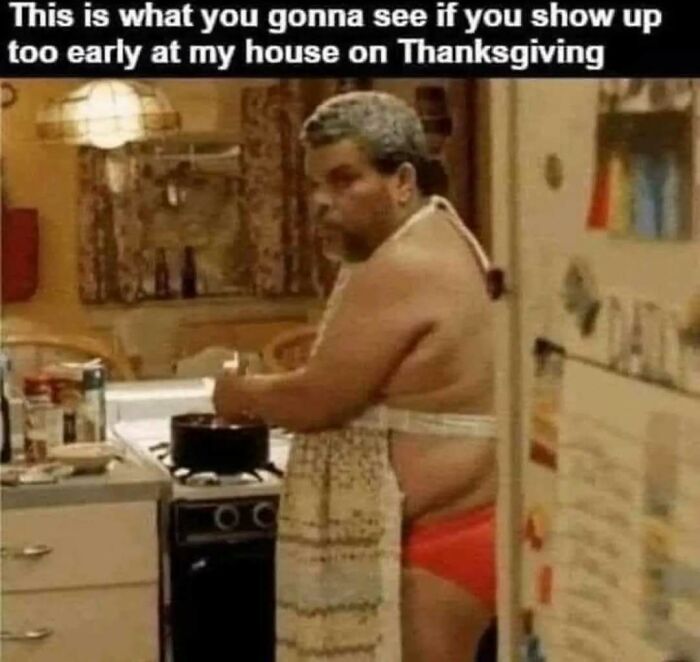 Man cooking in kitchen wearing red underwear and apron, relatable meme humor about showing up too early on Thanksgiving.
