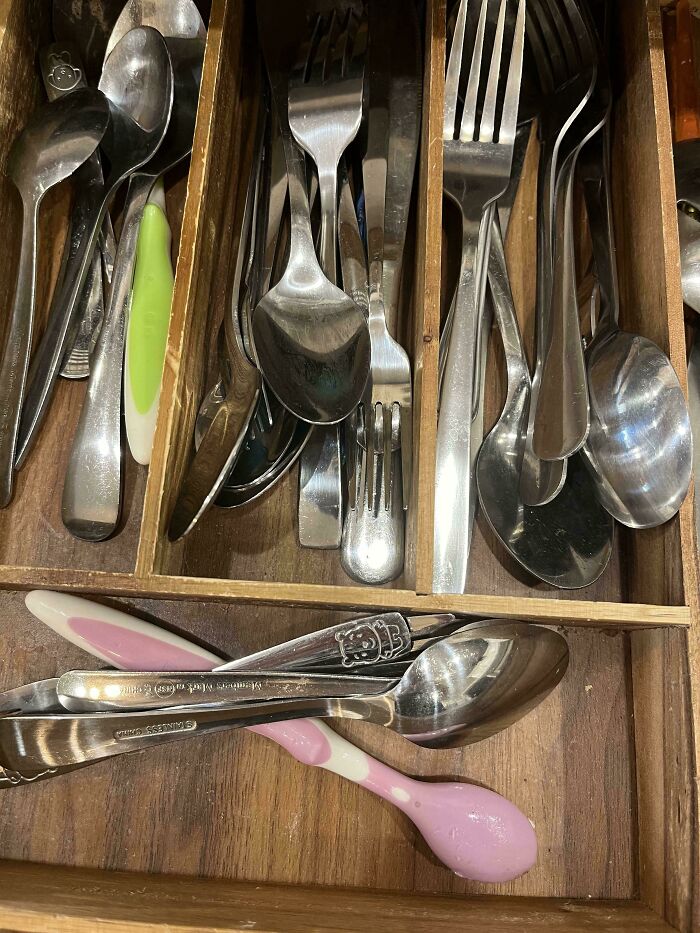 Disorganized cutlery drawer potentially causing frustration among family members.