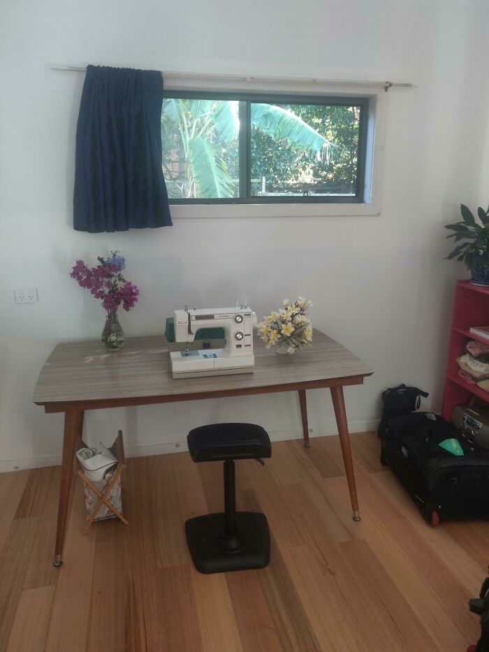 Sewing machine on a wooden table with flowers, showcasing amazing creativity by mothers-in-law.
