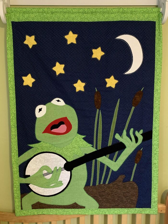 Quilt with a green frog playing banjo under stars and moon, crafted beautifully; perfect mother-in-law gift.