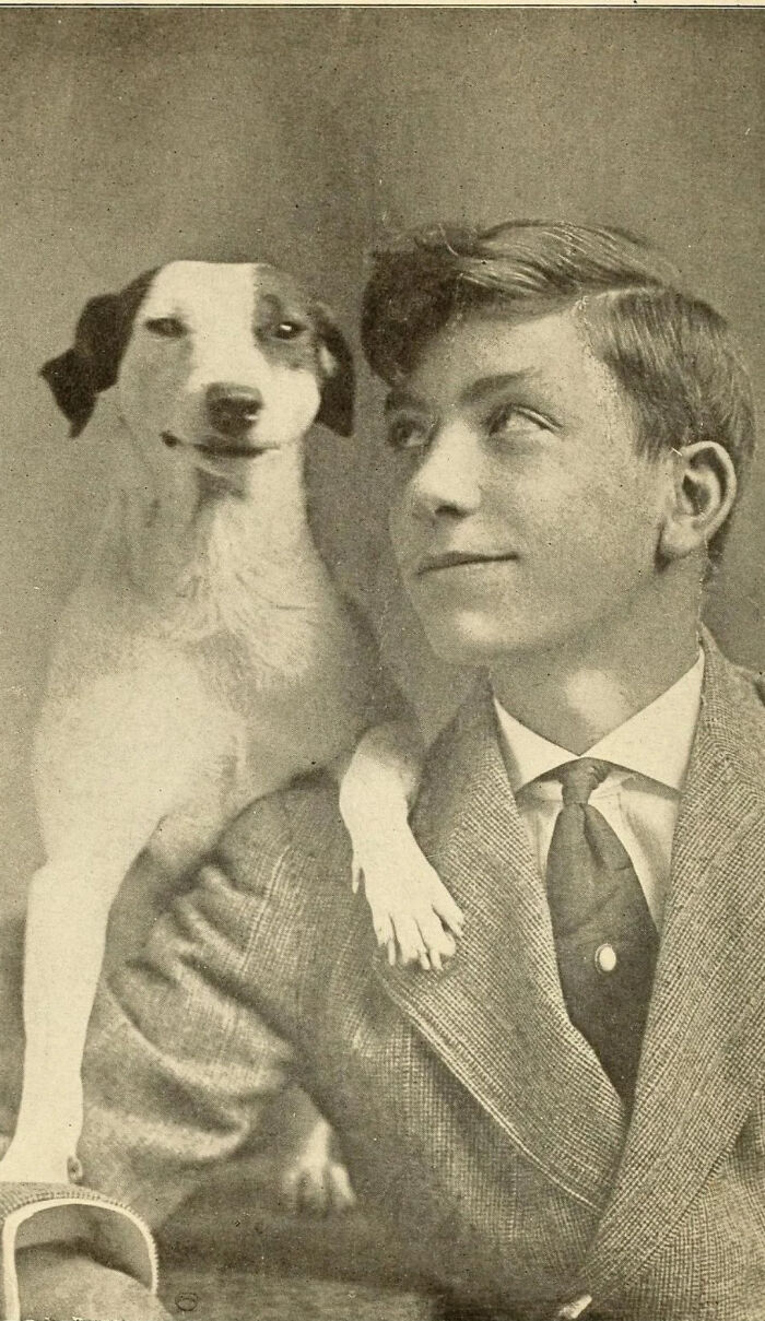 Vintage photo of a young man smiling with a dog putting its paw on his shoulder, showcasing pets as family.