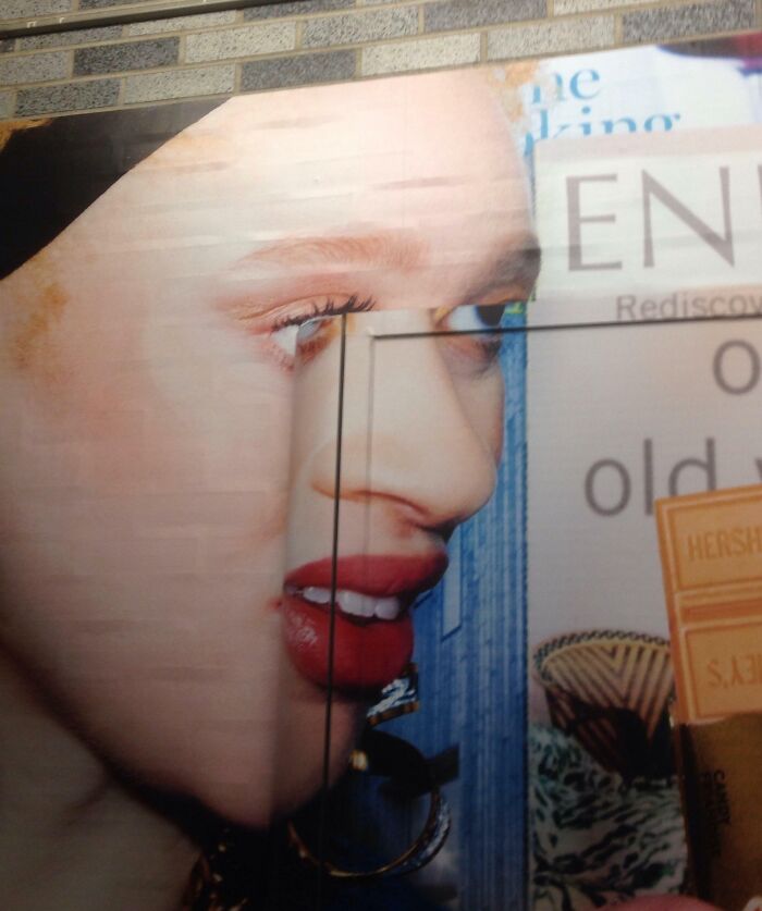 Billboard with a woman's face misaligned due to door frame, showcasing a funny ad fail.