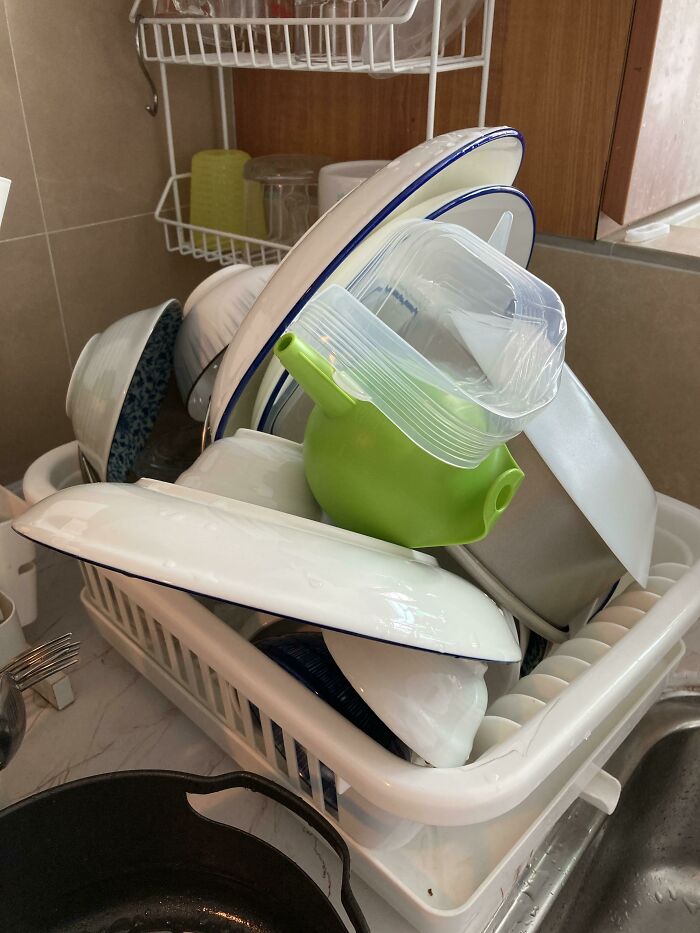 Overflowing dish rack with stacked plates and bowls, symbolizing infuriating family members.
