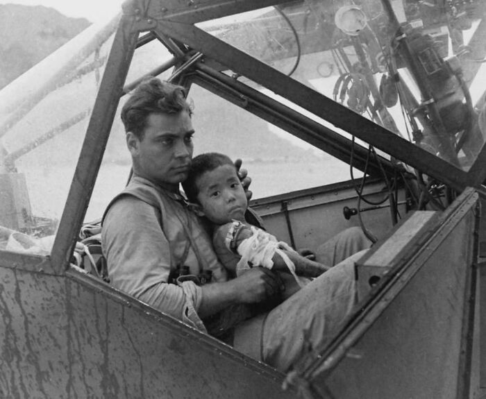 Pilot holding a child in a cockpit, an unseen historical moment not found in textbooks.