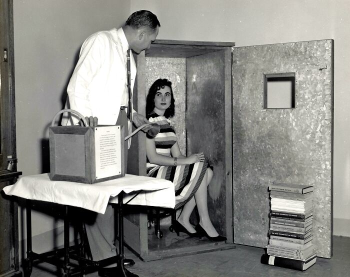 Man and woman with a wooden box and books, illustrating unusual historical classroom experiment not seen in history textbooks.