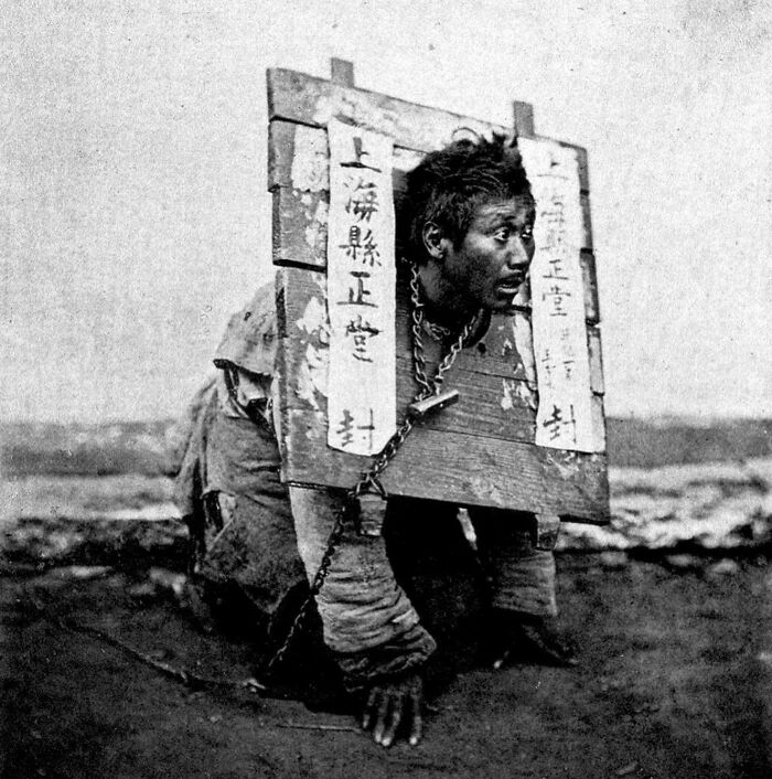 Historical photo of a man restrained with a wooden collar, a stark scene not found in most history textbooks.
