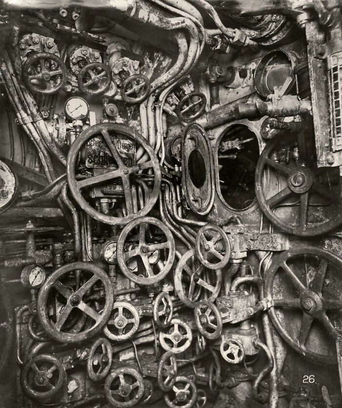 Historic submarine control room with numerous wheels and gauges, likely unseen in textbooks.