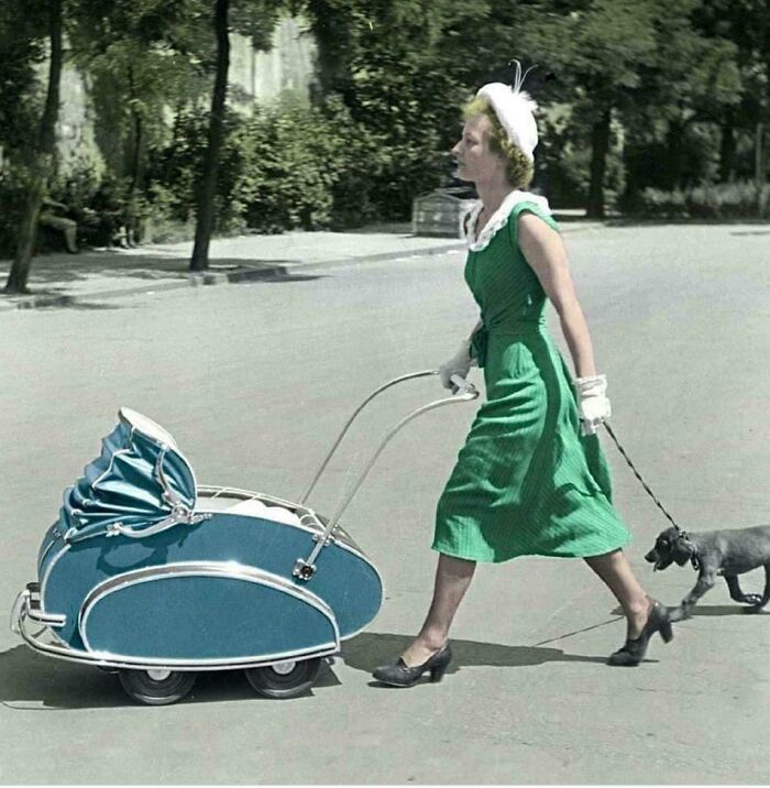 Woman in a vintage green dress walking a dog and baby carriage, representing unseen historical moments.