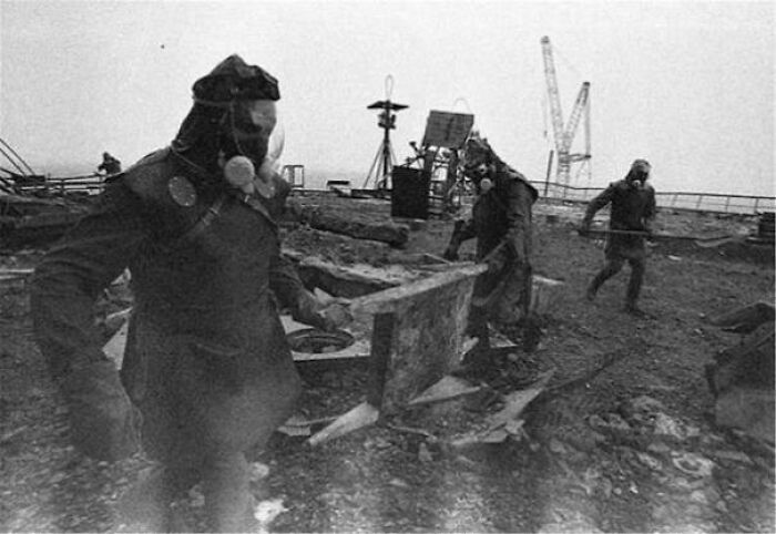 Workers in protective gear at a historical industrial site, unseen in typical textbooks.
