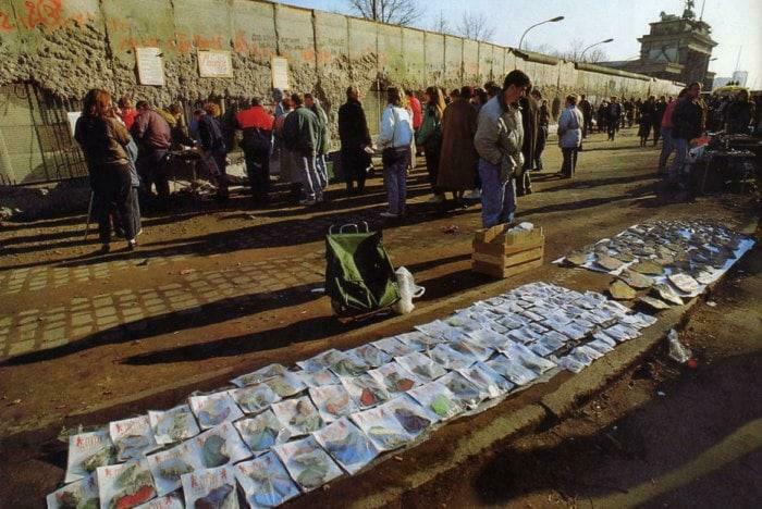 People gathering and viewing art along the Berlin Wall, showcasing photos not seen in your history textbooks.