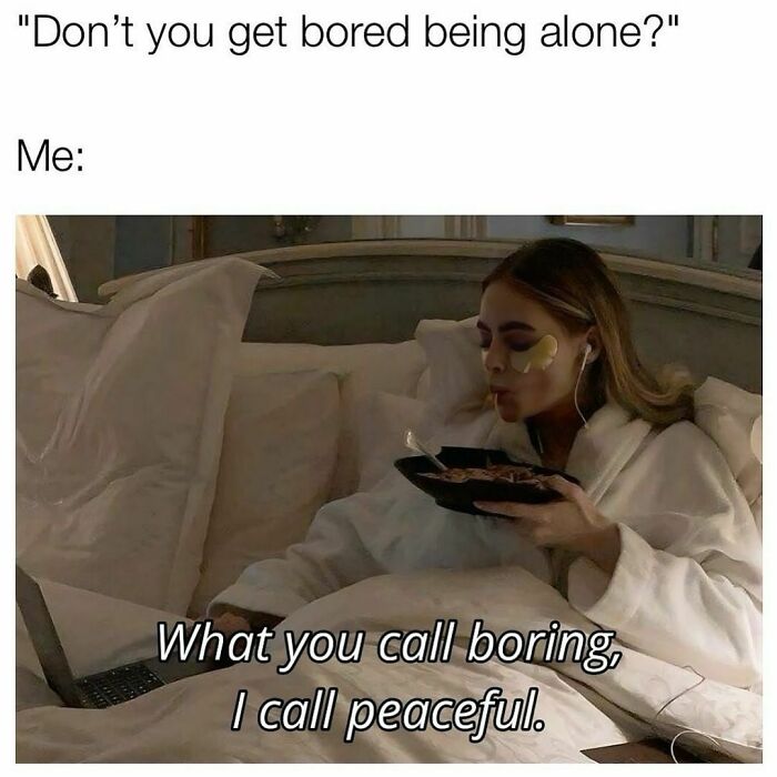 Woman relaxing in bed with a laptop, wearing under-eye patches, enjoying alone time.