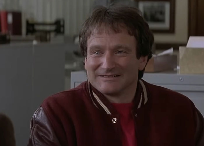 Person in a vintage jacket smiles warmly, evoking '90s nostalgia.