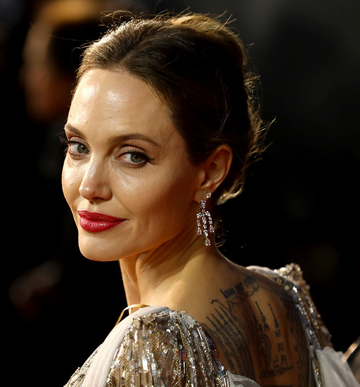 Angelina Jolie with a glamorous look, sparking Vogue Mexico cover backlash, wearing sparkling earrings and a sequin dress.