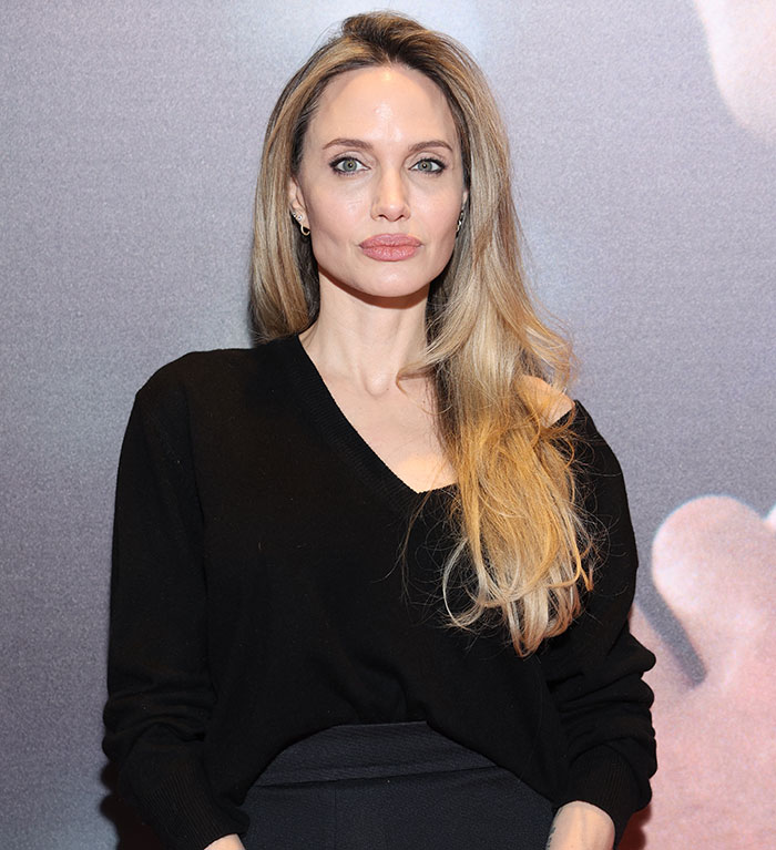 Angelina Jolie posing in a black outfit.