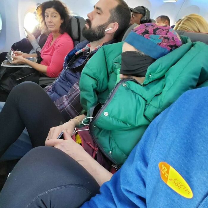 Annoying plane passengers, including one asleep with a green jacket and eye mask, in a crowded airplane cabin.