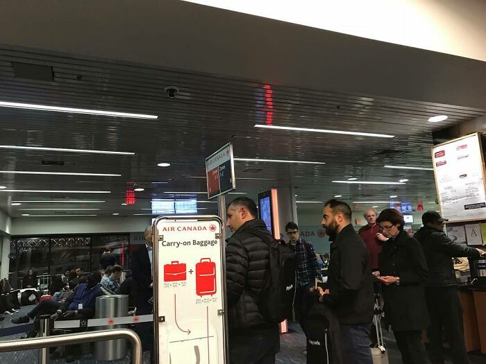 Passengers wait in line at an airport gate, showcasing travel dynamics and potential annoying plane passengers.