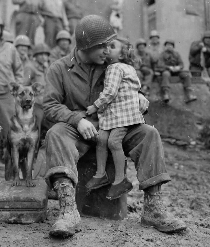 Elvin Harley Of Kalamazoo, Michigan, Of The 3rd Armored Division, Gets A Peck On The Cheek From A French Girl While Listening To The 9th Armored Division Band Near Aboncourt, France. February 14, 1945