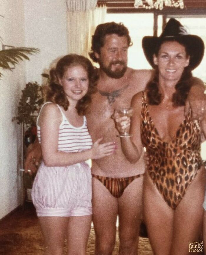 Awkward family photo with three people in matching animal print swimwear, smiling at a social gathering.
