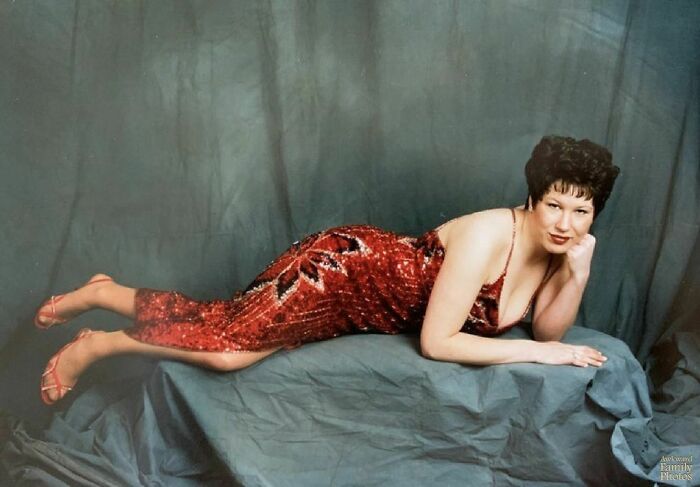 Person in a sparkly red dress posing on a draped surface, capturing a memorable family photo moment.