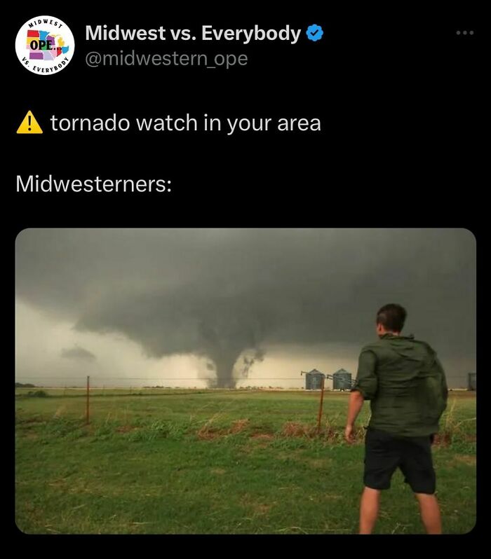 Man watching a tornado in a field, showcasing unique Midwest attitude during a storm warning.