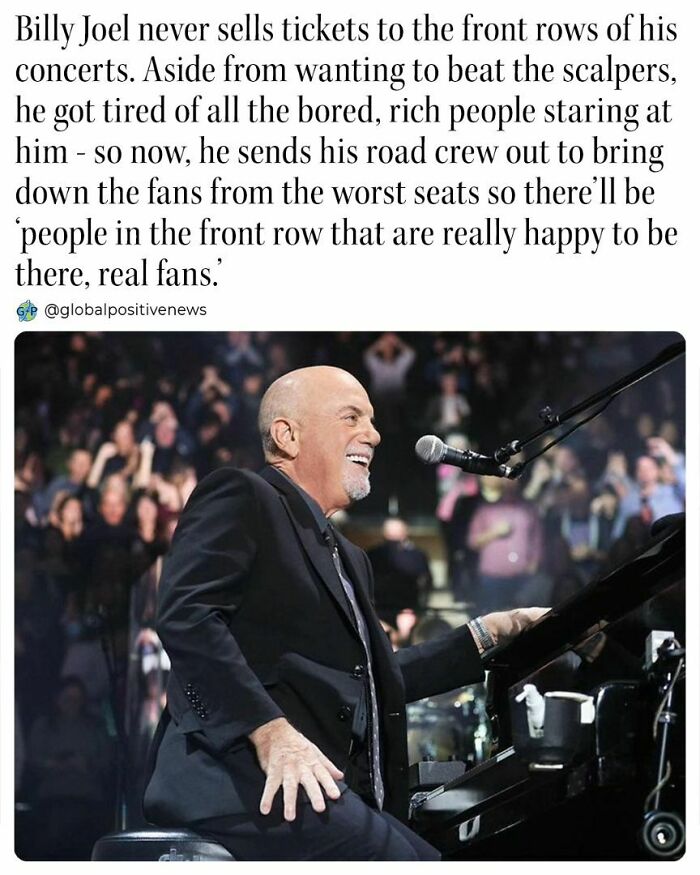 Man in a suit playing piano at a concert, smiling, with crowd in background, embodying uplifting stories.