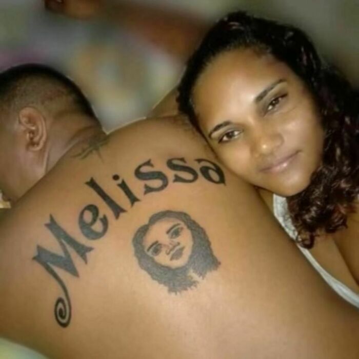 Man with a tattoo of the name "Melissa" and a face on his back, highlighting a permanent tattoo mistake.