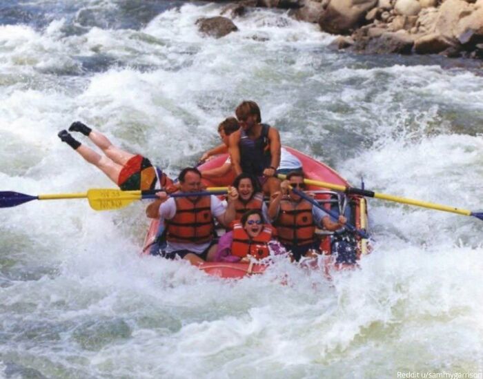 Family rafting adventure gone awry, with two members hilariously off-balance, creating a viral photo moment.