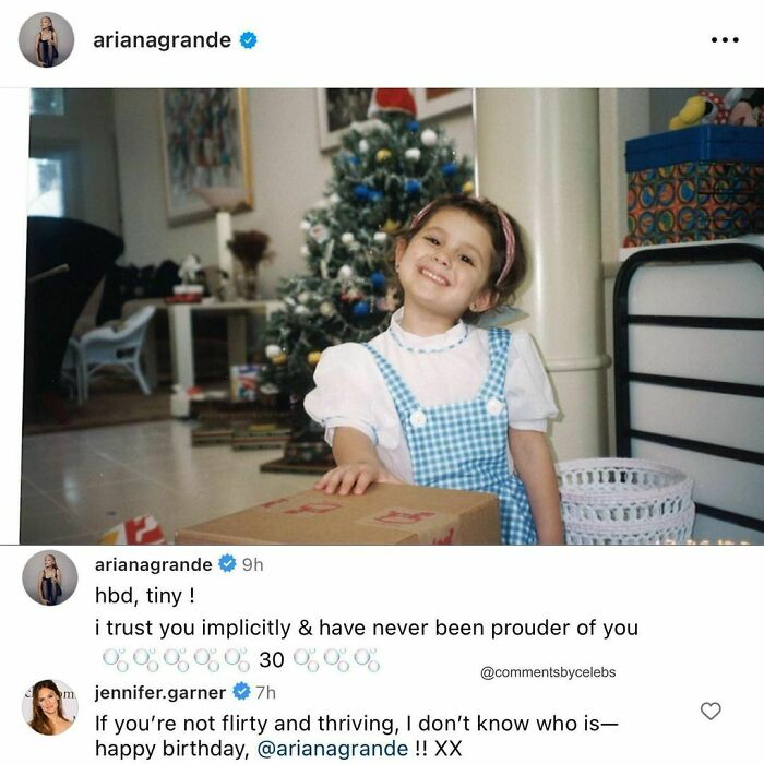 Child in front of a Christmas tree with funny celeb comments about a birthday.