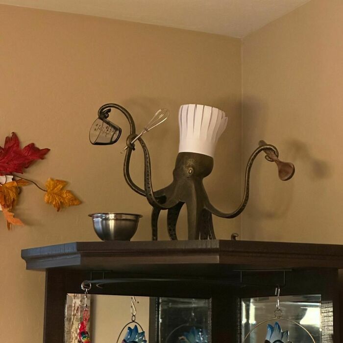 Thanksgiving home decor featuring an octopus sculpture with a chef hat holding kitchen utensils on display.