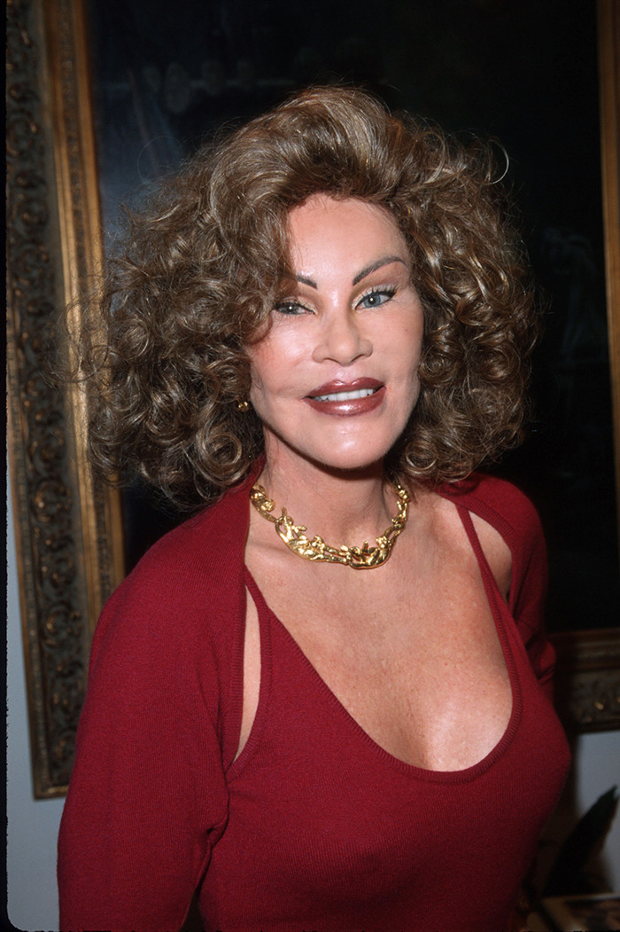 Jocelyn Wildenstein in red top and gold necklace, smiling confidently. Jocelyn Wildenstein in red top and gold necklace, smiling confidently.