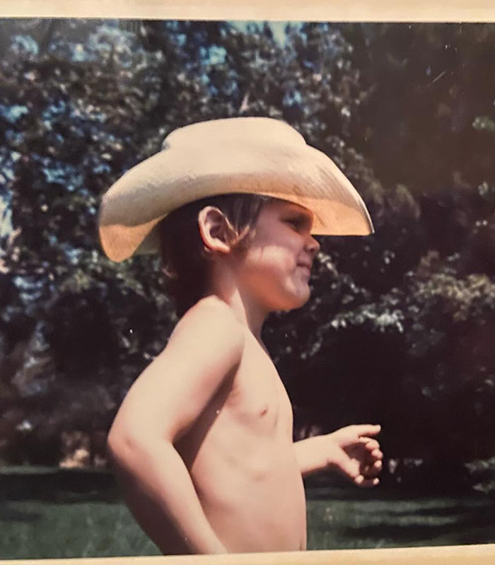 Child wearing a cowboy hat outdoors, with trees in the background, referencing mountain lions and cougars.