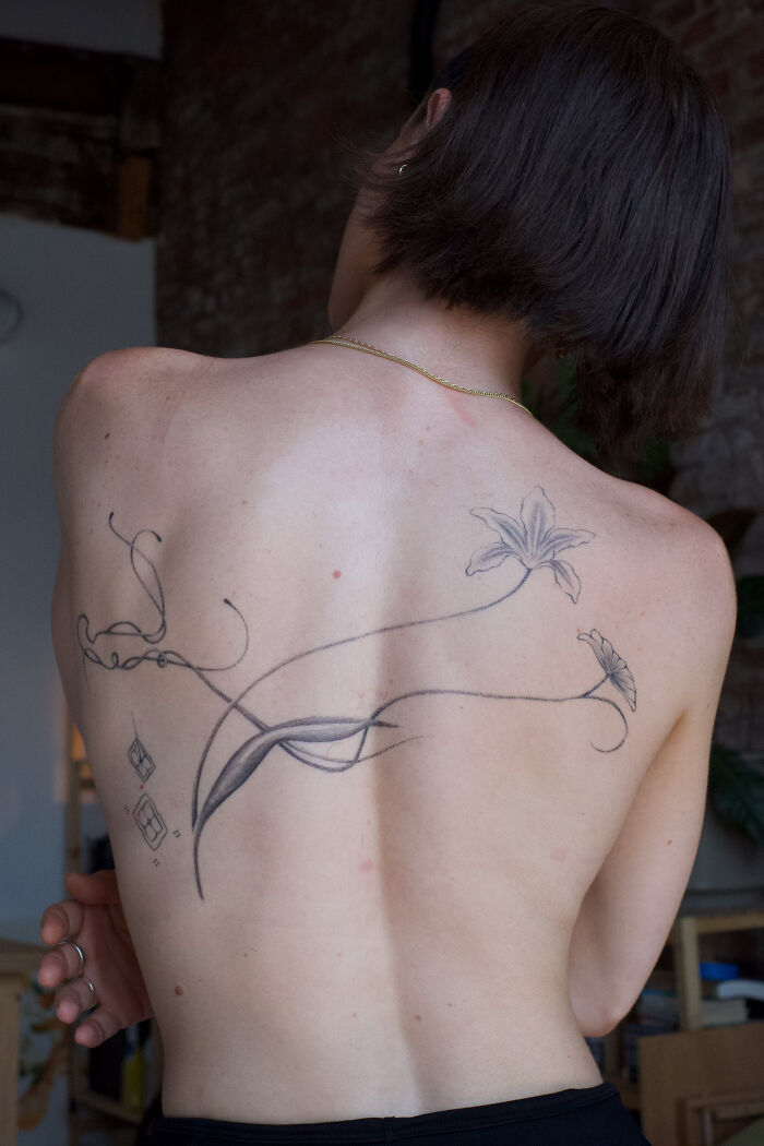 Back tattoo featuring floral design by Monolith Studio artist.