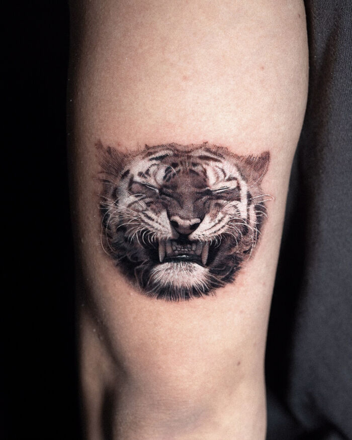Tattoo of a roaring tiger on an arm, created by Monolith Studio artist.